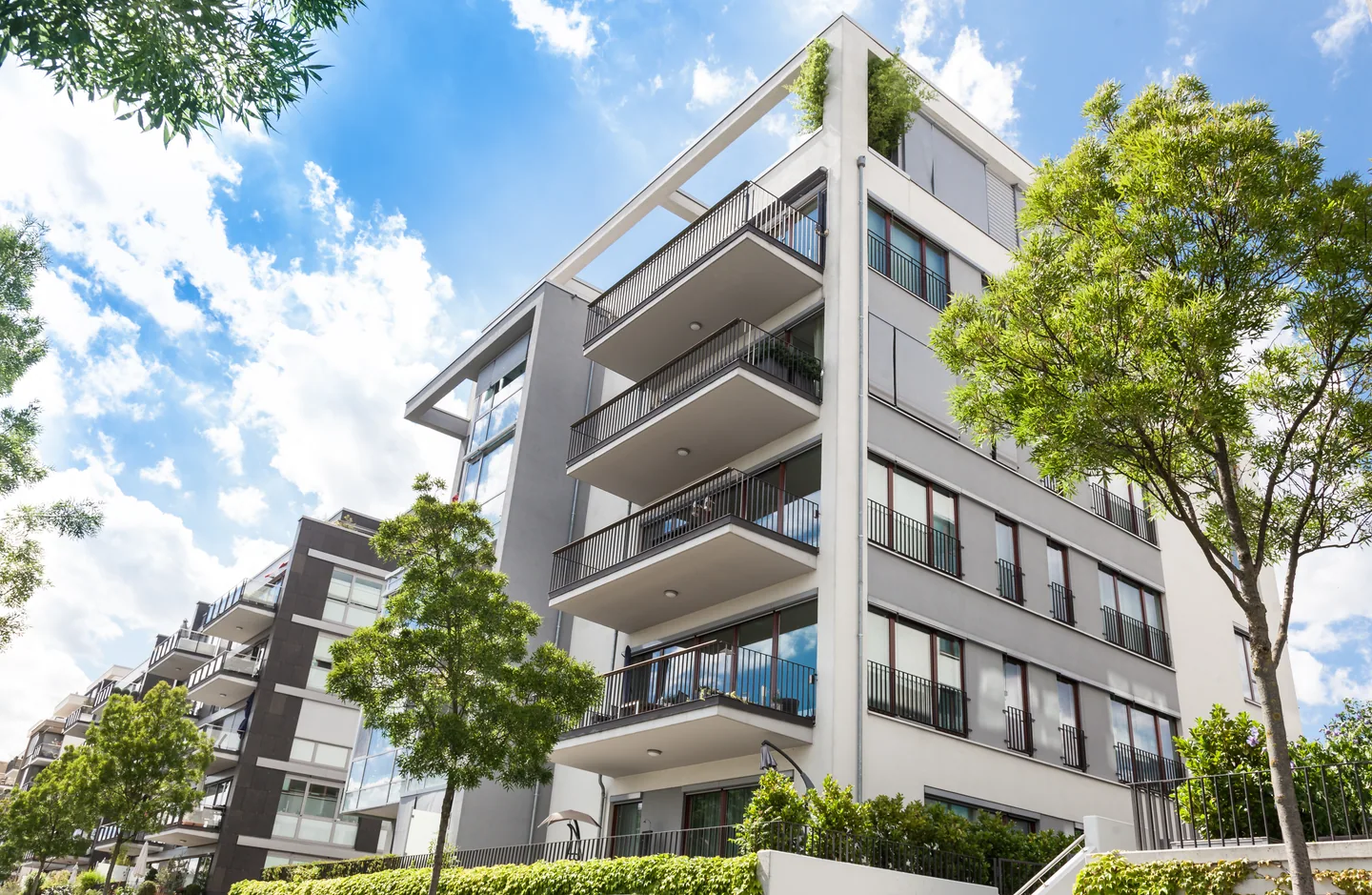 Apartment balconies surrounded by green trees